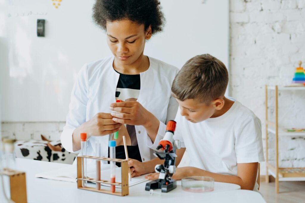 a boy sitting at the table with his teacher