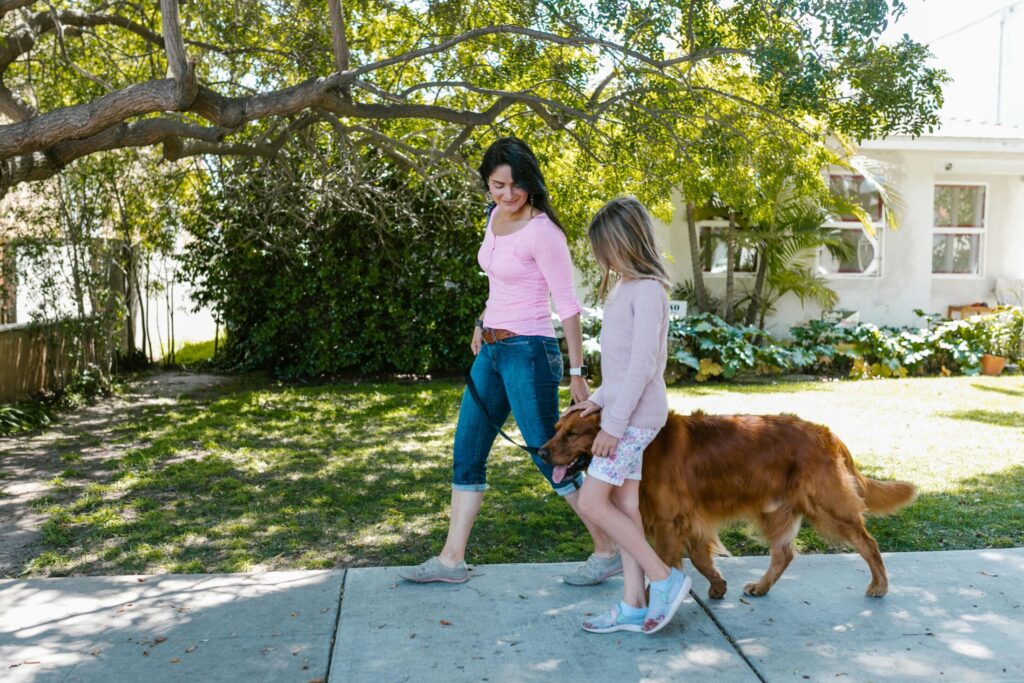 a woman and girl walking their dog
